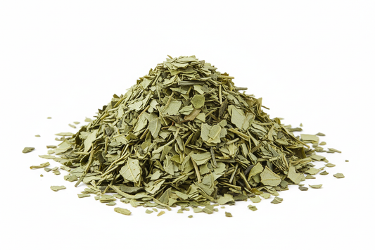 Un montoncito de té verde en escamas sobre fondo blanco